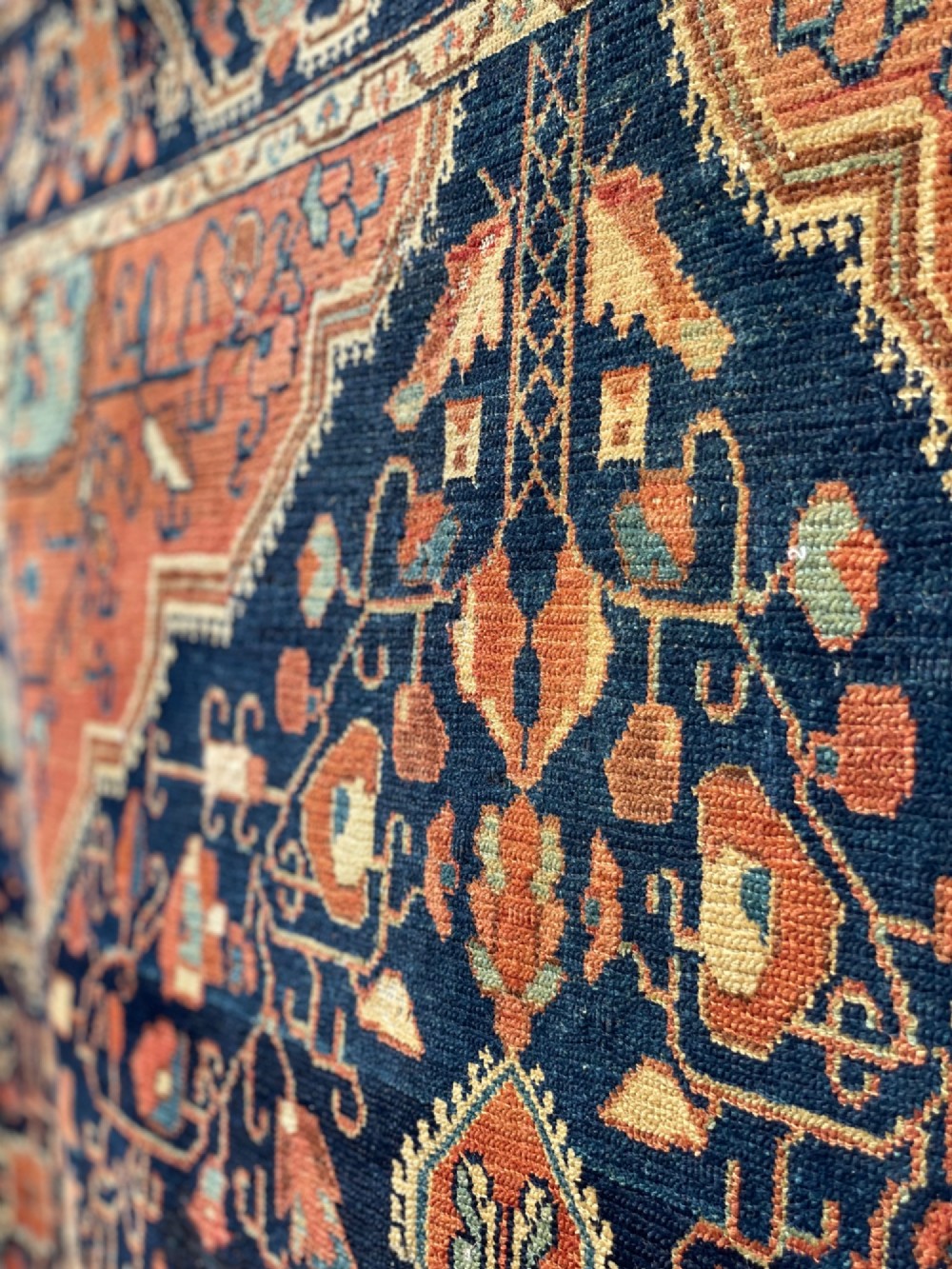 An antique hand-knotted Persian Jozan wool rug featuring a dark navy field filled with floral motifs around a central terracotta red diamond medallion and matching spandrels. View VI