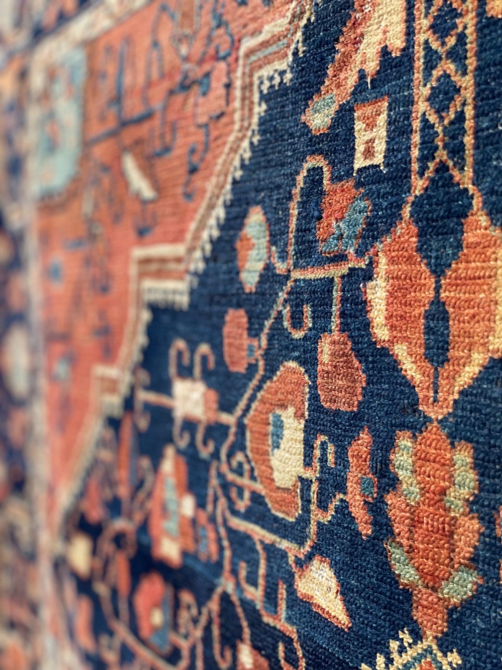 An antique hand-knotted Persian Jozan wool rug featuring a dark navy field filled with floral motifs around a central terracotta red diamond medallion and matching spandrels. View VII