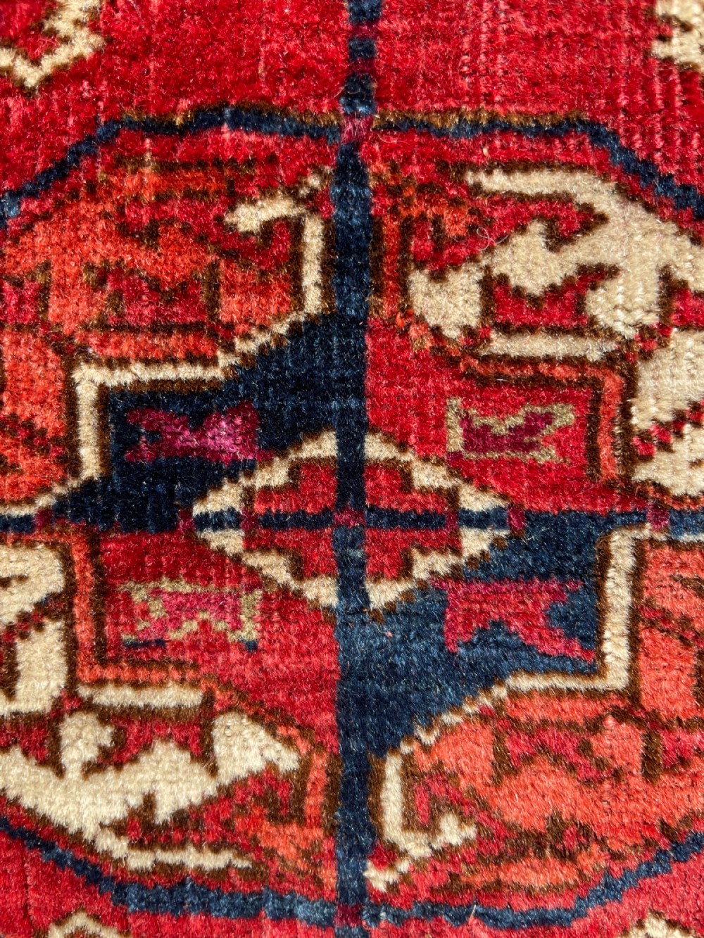 An antique hand-knotted Tekke Turkoman dowry rug featuring repeating octagonal gol motifs in deep red, navy blue, and ivory silk accents. View XIII