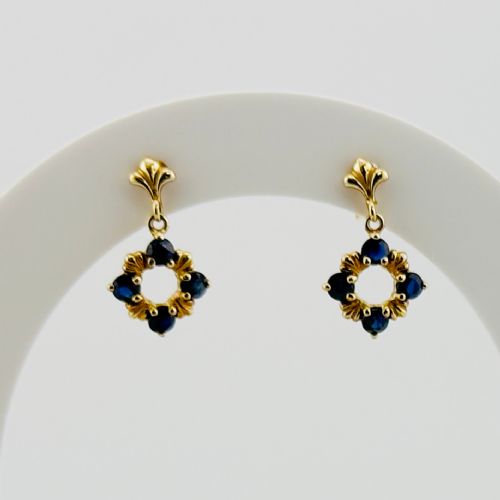 fig 1. A pair of 9ct yellow gold drop earrings, each featuring a stud top with a suspended open circular pendant set with four dark blue sapphires.