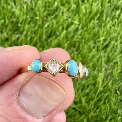 fig 1. An 18ct yellow gold ring set with three cabochon blue turquoise stones alternating with two diamond-shaped collets housing round diamonds.