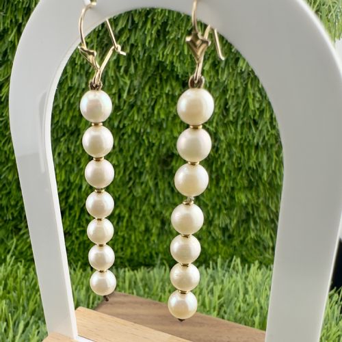 fig 1. A vertical linear drop earring featuring seven round cream cultured pearls mounted on a 9ct gold fitting.