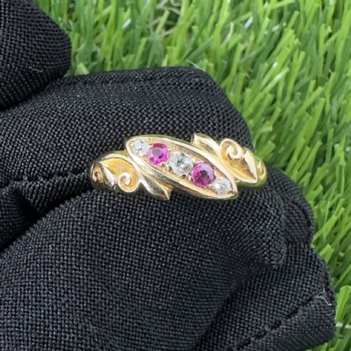 fig 1. An 18ct yellow gold Edwardian ring featuring scroll detailing and a central inset row of rubies and diamonds.