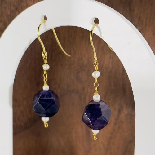 fig 1. A pair of 9ct yellow gold drop earrings featuring geometric faceted purple amethyst beads accented with small white seed pearls.