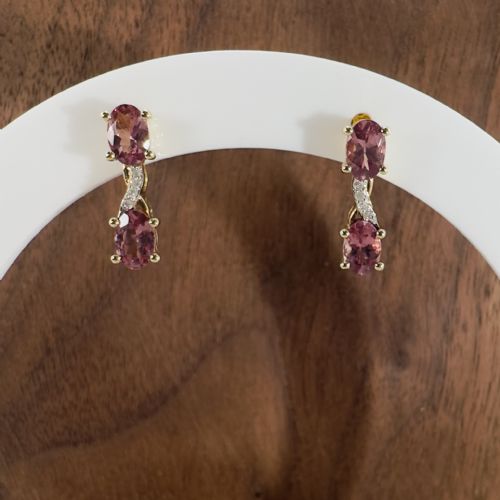 fig 1. A pair of 9ct yellow gold drop earrings featuring two vertically arranged oval cut pink spinels connected by a diamond-set accent bridge.