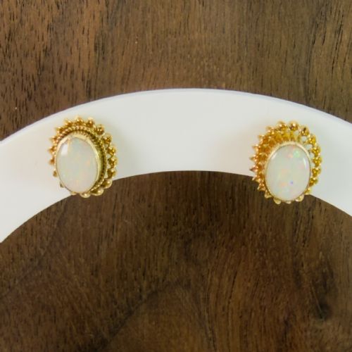 fig 1. A pair of 9ct yellow gold stud earrings featuring central oval opal cabochons surrounded by textured gold rope borders.