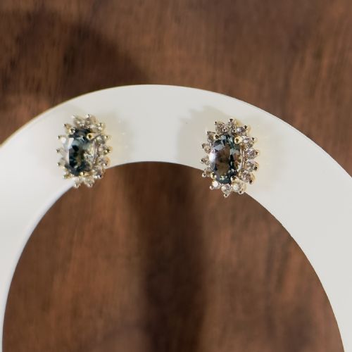 fig 1. A pair of 9ct yellow gold stud earrings featuring central oval cut andalusite gemstones surrounded by a halo of small diamonds.