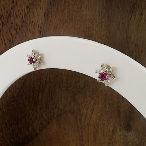 fig 1. A pair of 9ct yellow gold cluster stud earrings featuring a central round red ruby framed by white zircon accent stones.