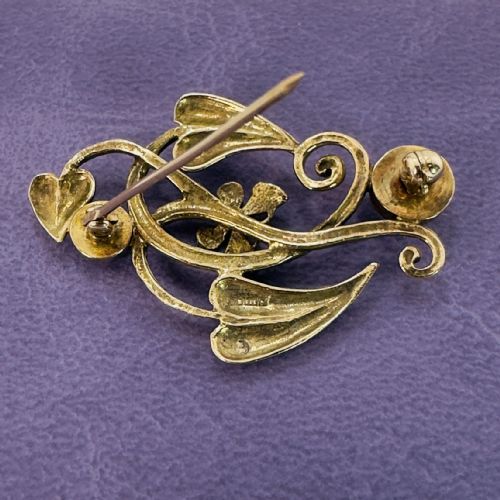 fig 1. A 9ct gold Art Nouveau brooch featuring flowing whiplash leaves, a central butterfly motif, and two bezel-set round moonstones.