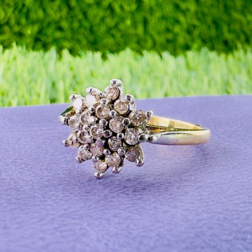 fig 1. An 18ct yellow gold ring featuring a raised multi-diamond cluster setting in a circular starburst motif.