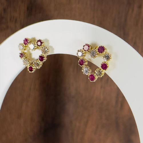 fig 1. A pair of 9ct yellow gold heart-shaped stud earrings set with alternating round red rubies and clear white spinels.