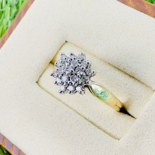fig 1. An 18ct yellow gold cluster ring set with round diamonds in a starburst pattern on a plain polished band.