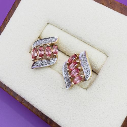 fig 1. A pair of 18ct yellow gold stud earrings, each set with four marquise-cut pink padparadscha sapphires flanked by a swirl of diamonds.