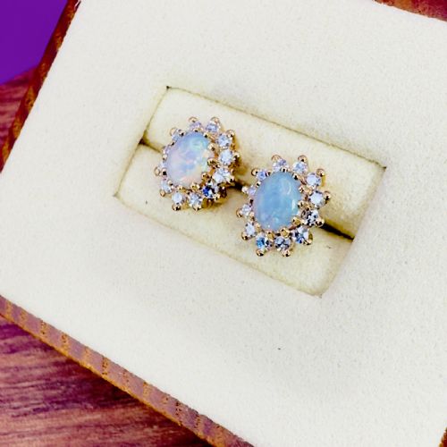 fig 1. Pair of 9ct yellow gold stud earrings featuring central oval cabochon opals surrounded by a halo cluster of small diamonds.