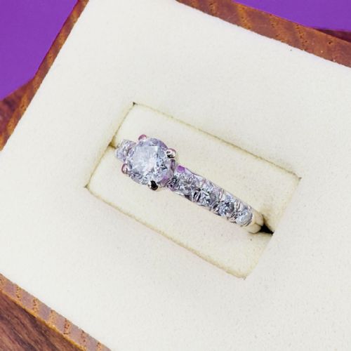 fig 1. An 18ct white gold engagement ring featuring a round brilliant-cut central diamond flanked by smaller diamonds set along the shoulders.