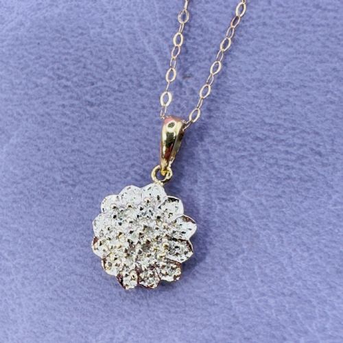 fig 1. A 9ct yellow gold starburst cluster pendant with pave-set diamonds suspended from a fine gold link chain.