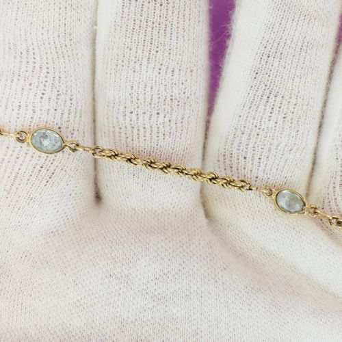 fig 1. A 9ct yellow gold rope twist chain bracelet featuring three bezel-mounted oval blue topaz gemstones.