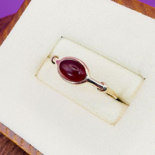 fig 1. A Georgian 9ct gold solitaire ring featuring a smooth, oval red carnelian cabochon set in a bezel setting with subtle shoulder detail.