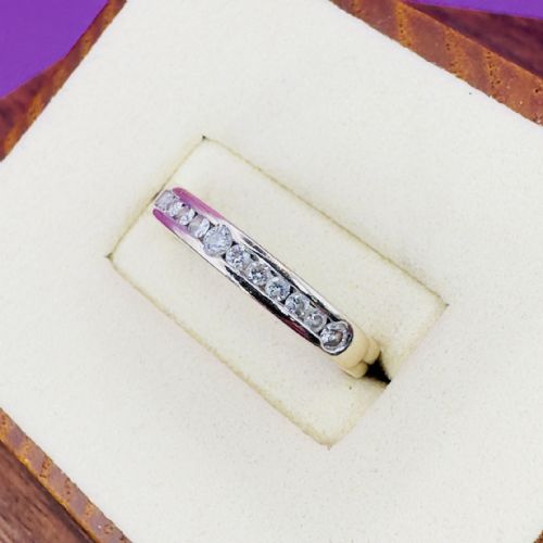 fig 1. An 18ct white gold half eternity ring set with a row of round brilliant cut diamonds along the top of the polished band.
