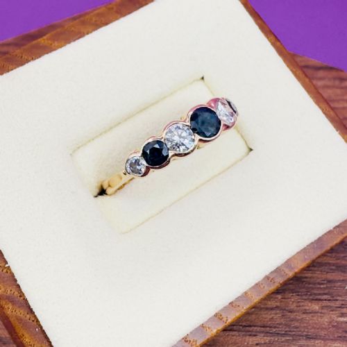 fig 1. An 18ct yellow gold half eternity ring featuring seven alternating set sapphires and diamonds across the band.