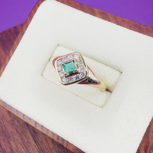 fig 1. An 18ct yellow gold ring featuring a central square princess cut green emerald surrounded by a diamond halo cluster.