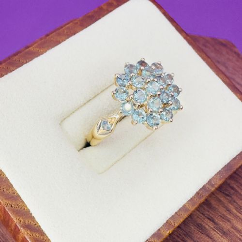 fig 1. A 14ct yellow gold cluster ring set with round light green tsavorite garnets in a multi-tier floral arrangement.
