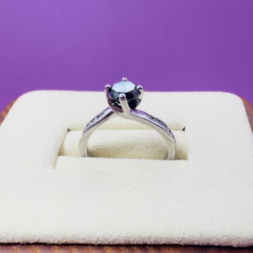 fig 1. A platinum twist solitaire ring featuring a round brilliant black diamond held in a four-claw setting with small white diamonds accenting the shoulders.