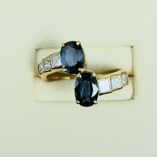 fig 1. An 18ct yellow gold Art Deco ring featuring two oval-cut blue sapphires in a crossover setting with stepped shoulders set with princess-cut diamonds.
