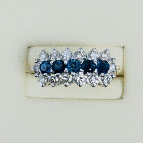 fig 1. An 18ct gold cluster boat ring featuring five round blue sapphires surrounded by a halo of brilliant diamonds.