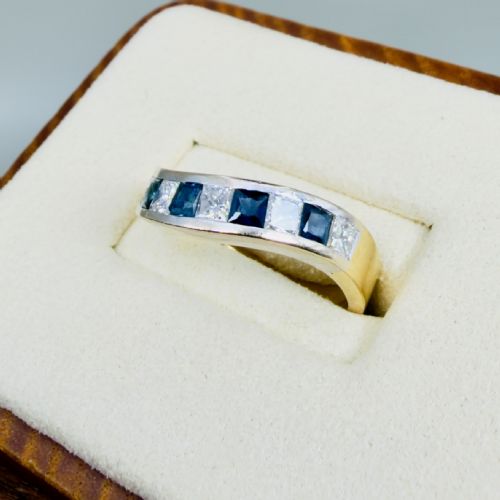 fig 1. An 18ct yellow gold wave-shaped half eternity ring featuring channel-set alternating princess-cut diamonds and square blue sapphires.