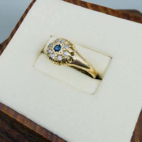 fig 1. A mid-Victorian 18ct yellow gold ring featuring a central blue sapphire surrounded by a cluster of diamonds in a carved starburst setting.
