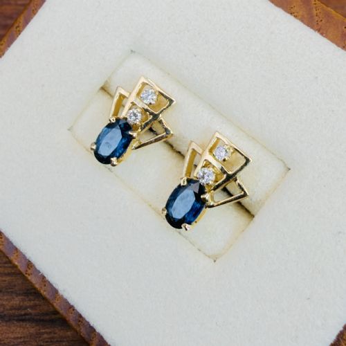fig 1. A pair of 18ct yellow gold Art Deco stud earrings featuring an oval blue sapphire topped with two round diamonds inside a geometric openwork frame.