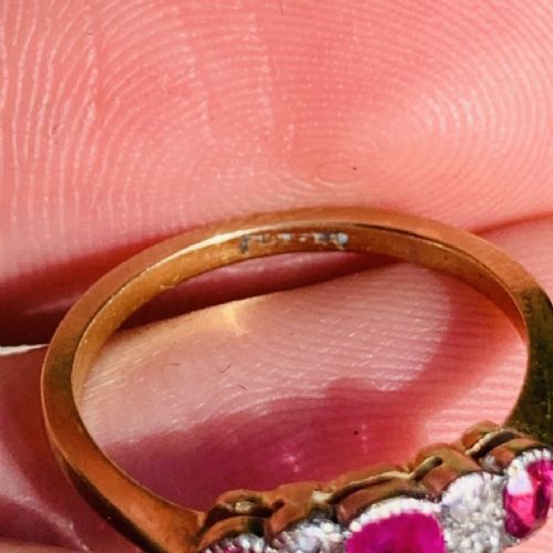 An 18ct yellow gold ring featuring three oval pinkish-red rubies interspersed with pairs of small round old-cut diamonds in a platinum setting. View VII