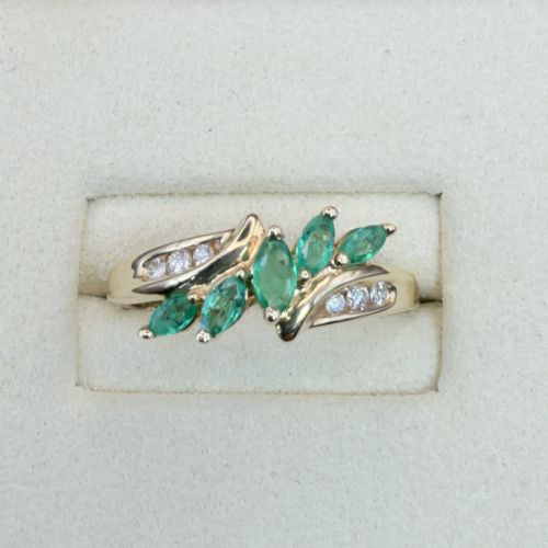 fig 1. A 14ct yellow gold cluster ring set with five marquise-cut green emeralds flanked by channel-set diamonds.