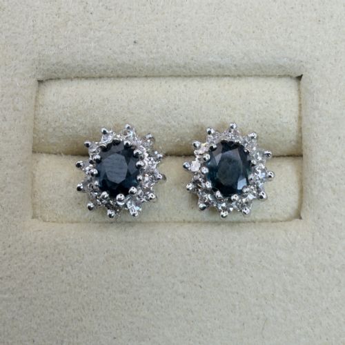 fig 1. A pair of vintage 9ct gold stud earrings featuring oval deep blue sapphires surrounded by clusters of small diamonds.