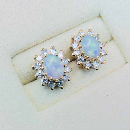 fig 1. A pair of 9ct yellow gold stud earrings featuring central oval cabochon opals surrounded by a halo of small brilliant-cut diamonds.