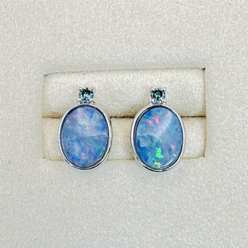 fig 1. A pair of 14ct white gold stud earrings featuring oval opal doublets with blue and green flashes, each crowned with a small round prong-set teal green diamond.