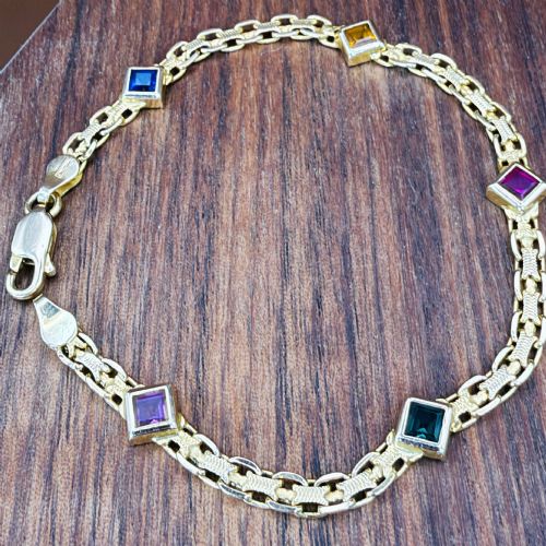 fig 1. A 14ct yellow gold textured link bracelet featuring five square princess-cut multi-coloured gemstones.