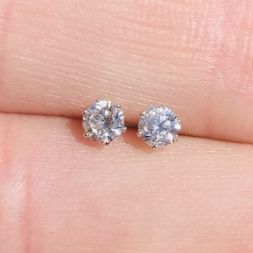 fig 1. A pair of round brilliant-cut solitaire diamond stud earrings set in six-claw platinum mounts.