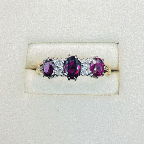 fig 1. An 18ct yellow gold ring featuring three oval red rubies separated by pairs of small diamonds set in a claw setting.