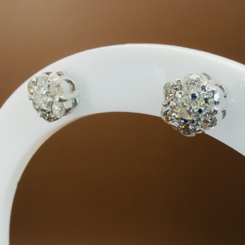fig 2. A pair of 18ct white gold cluster stud earrings featuring brilliant-cut diamonds arranged in a floral design.