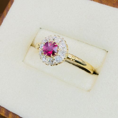 fig 2. An 18ct yellow gold Victorian ring featuring a central round red ruby surrounded by a halo of hand-cut diamonds.