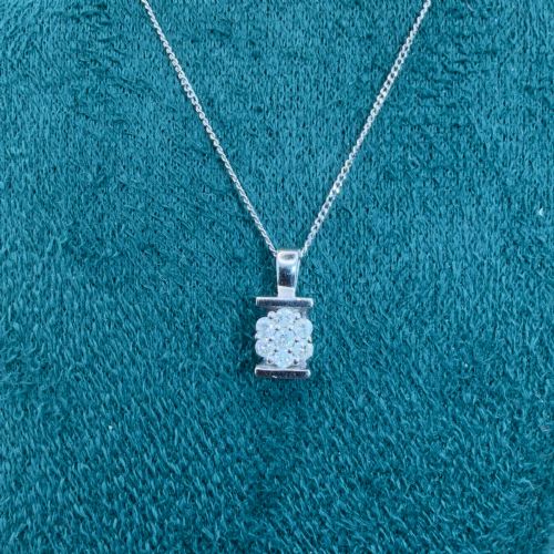 fig 2. A white gold jewellery set consisting of a fine chain necklace with a round diamond cluster pendant and matching cluster stud earrings.