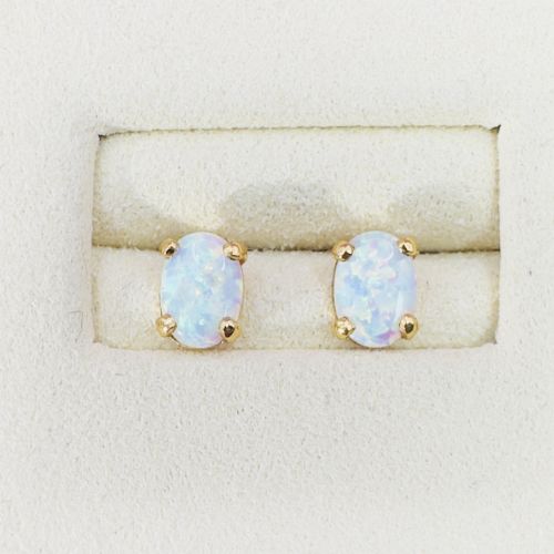 fig 1. A pair of 14ct yellow gold stud earrings featuring oval-cut white opals held in four-claw settings.