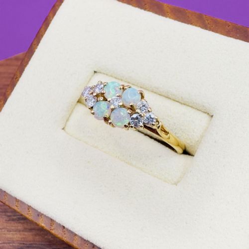 fig 2. An 18ct yellow gold cluster ring set with four round cabochon opals centrally and flanked by small diamonds.