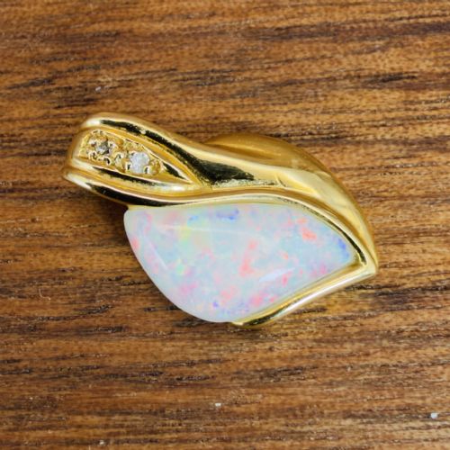 fig 1. An 18ct yellow gold freeform pendant displaying an iridescent white opal with green and pink flash, set alongside two accent diamonds on the bail.