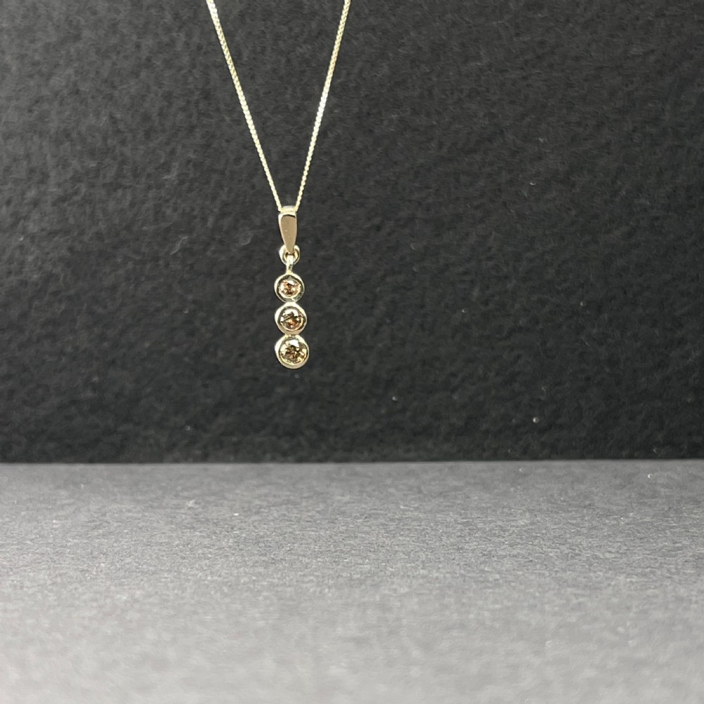 A 9ct yellow gold fine link chain necklace featuring a vertical drop pendant set with three round brilliant cut diamonds in bezel settings. View III