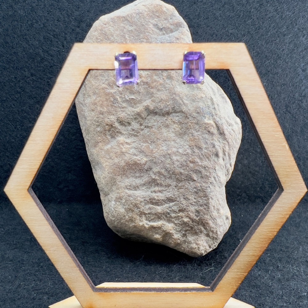 A pair of 9ct gold stud earrings mounted with rectangular emerald-cut purple amethyst gemstones and matching scroll backs. View VII