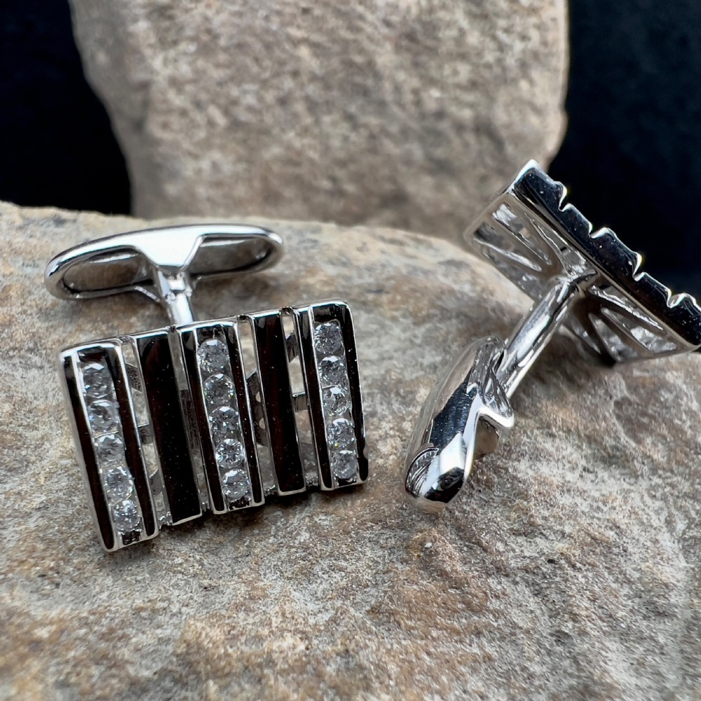 A pair of rectangular 9ct white gold cufflinks featuring alternating polished vertical bars and channel-set diamonds. View VII