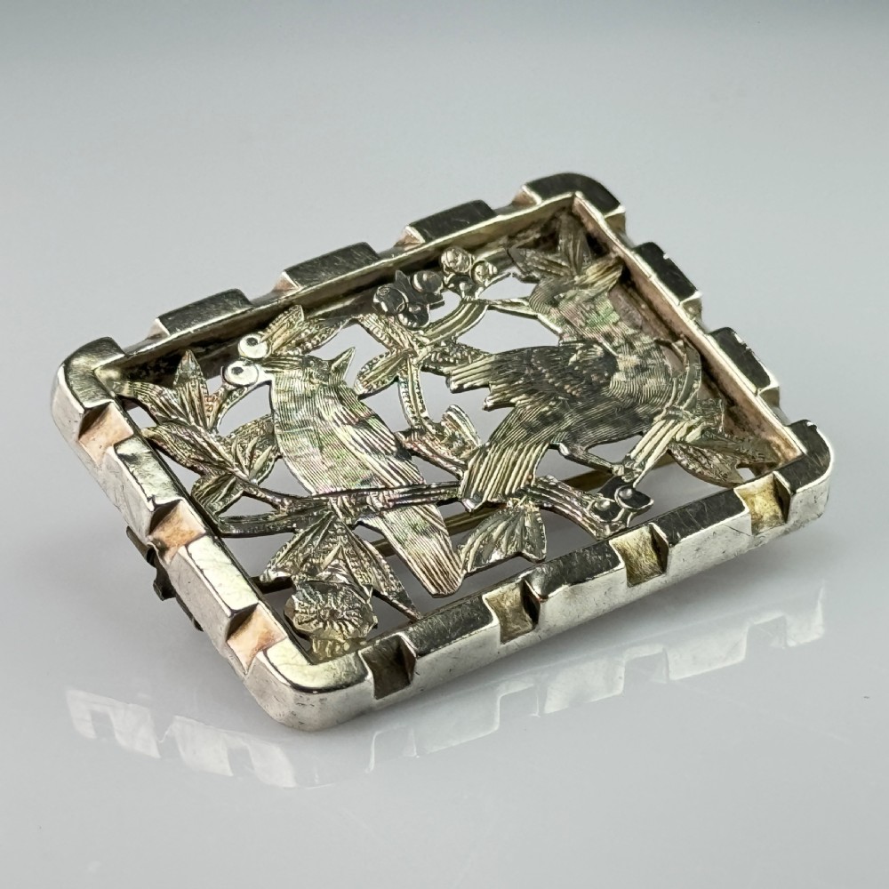 An antique rectangular silver openwork brooch depicting two detailed birds surrounded by foliage and berries. View II